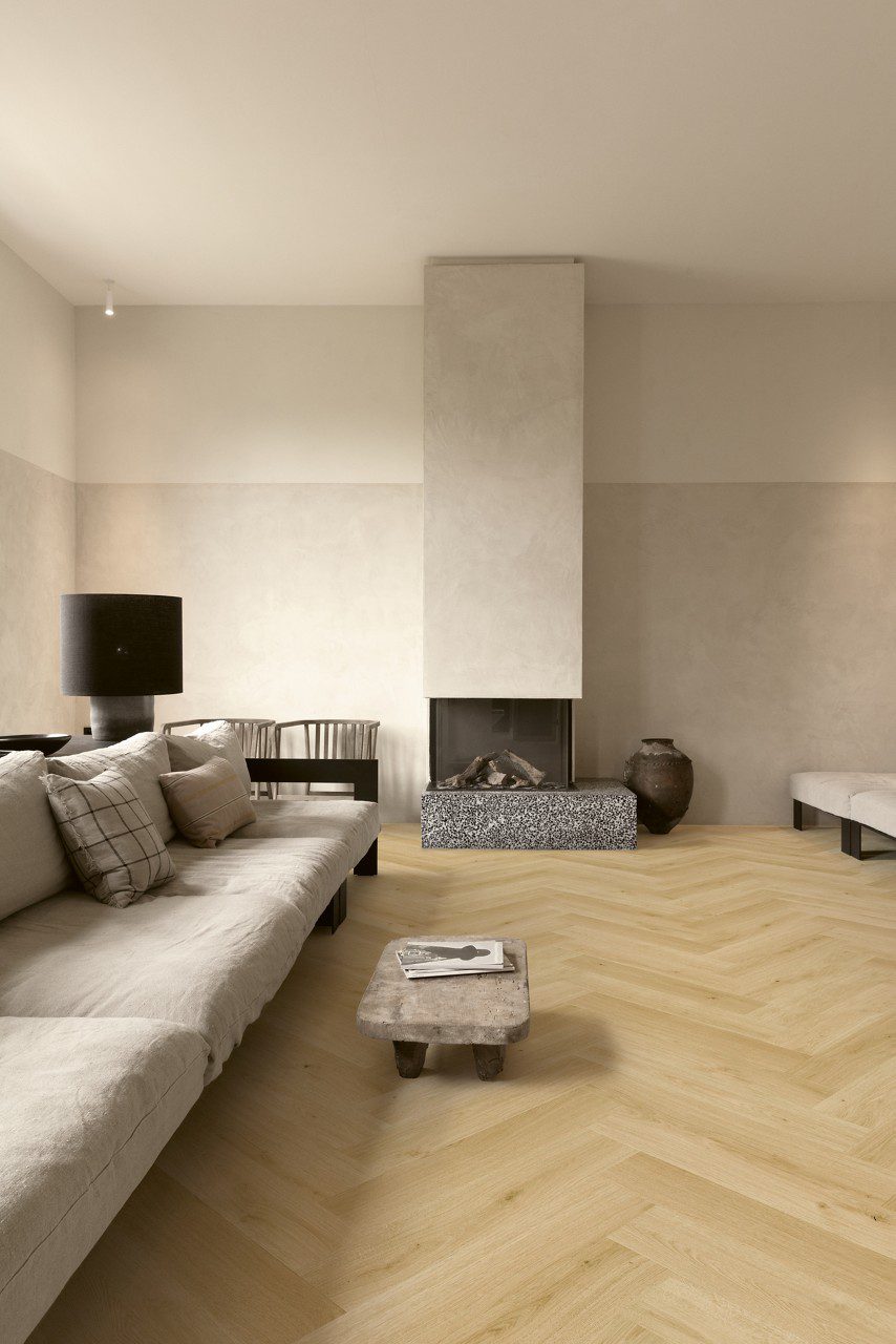 Fischgrät Laminatboden Quick Step Impressive Дизайн Gardamom Oak, verlegt im Wohnzimmerboden, Sofa, Tisch und Kamin