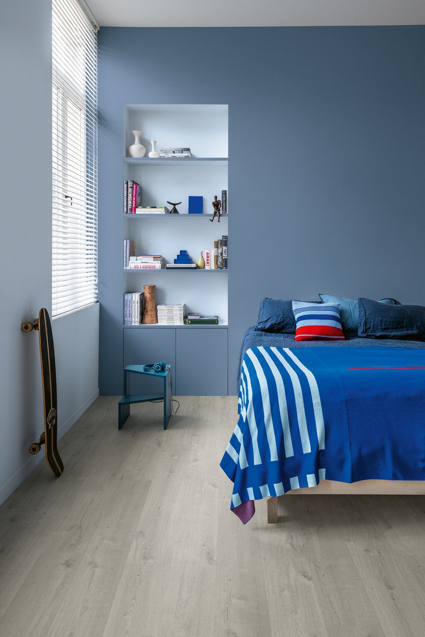 LVT parkett Quick-Step Bloom Cotton Oak Cold Grey paigaldatud lastetoa põrandale. Voodi, seina sisse ehitatud riiul, rula seina najal.