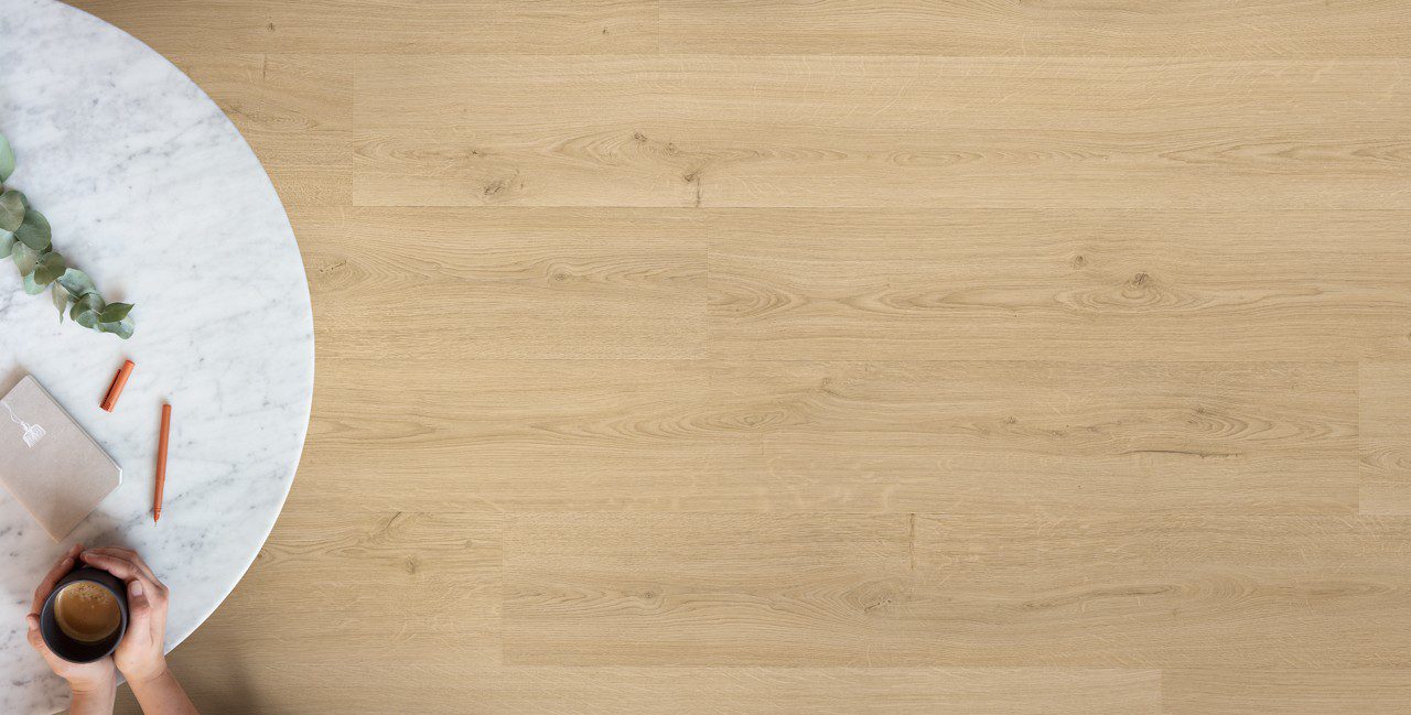LVT Quick-Step Bloom Botanic Beige paigaldatud põrandale. Valgest marmorist tasapinnaga laud.