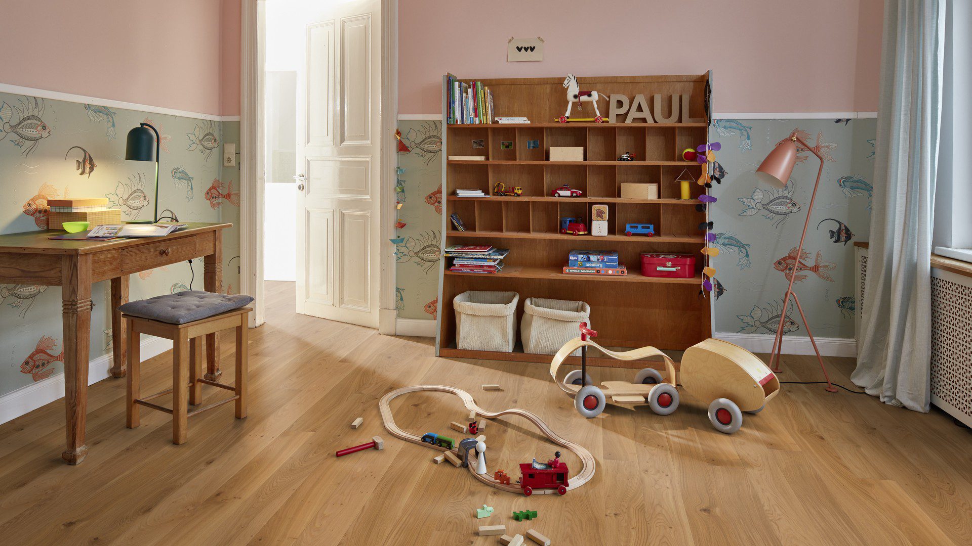 Tammiparketti Bauwerk Boen Casapark Budget Cut tammi 35, harjattu ja mattalakattu, asennettuna lastuhuoneen lattialle – hylly kuvakirjoineen ja leluineen, pöytä pienen tuolin kanssa sekä leikkiautoja lattialla. Luonnollinen, lämminsävyinen tammensävy ja kevyesti rustiikkinen sorteerus (maltillisesti oksakohtia ja hienovaraista sävyvaihtelua).