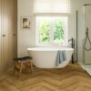 herringbone-laminate-floor-quick-step-impressive-design-cinnamon-oak Herringbone laminate floor Quick-Step Impressive Дизайн Cinnamon installed to bathroom floor. White separatly standind bathtub