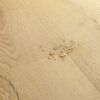 vinyylilattia-quick-step-bloom-brushed-oak-beige Vinyylilattia Quick Step Bloom Brushed Oak Beige, vaalea beige sävy ja harjattu tammikuviointi.