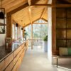 Vinyl flooring tiles installed on a 1-st floor kitchen. Rustical stile with wooden beams and boards ceiling. Rustical wooden kitchen furniture facade with dark marble top. Rustical golden wall tiles.