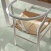 Vinylboden in Betonoptik Quick-Step Illume Soft Sage, verlegt auf dem Küchenboden – rustikaler Esstisch und Stuhl in Nahaufnahme; heller, sanfter Salbeigrün-Ton mit dezentem, steinartigem Дизайн.